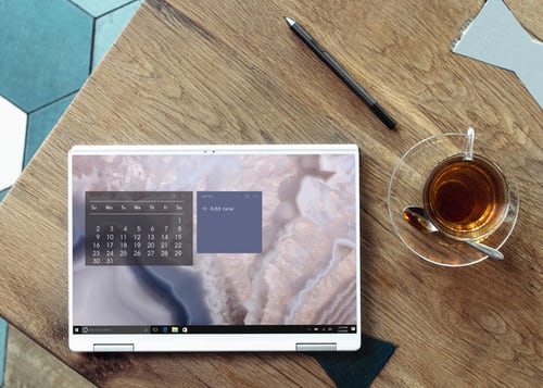 Photo of a calendar, a pen, and tea, on a wooden table.